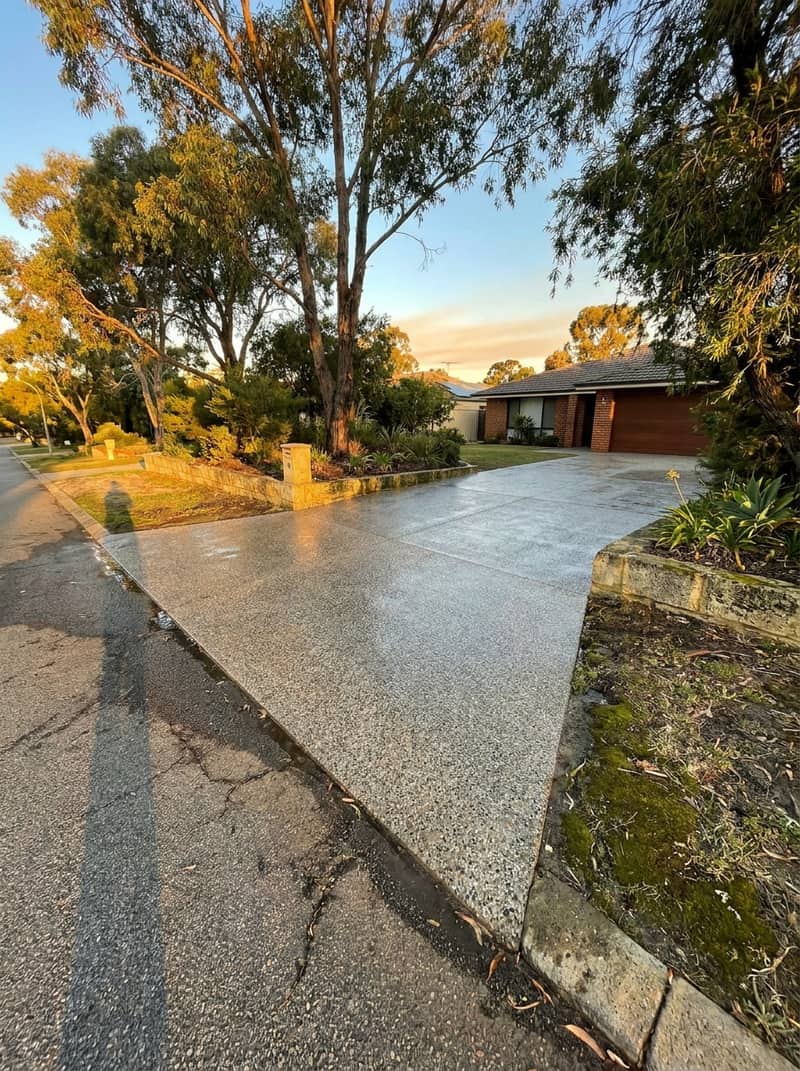 Pressure washing in progress on a Perth residential driveway showing dirt removal