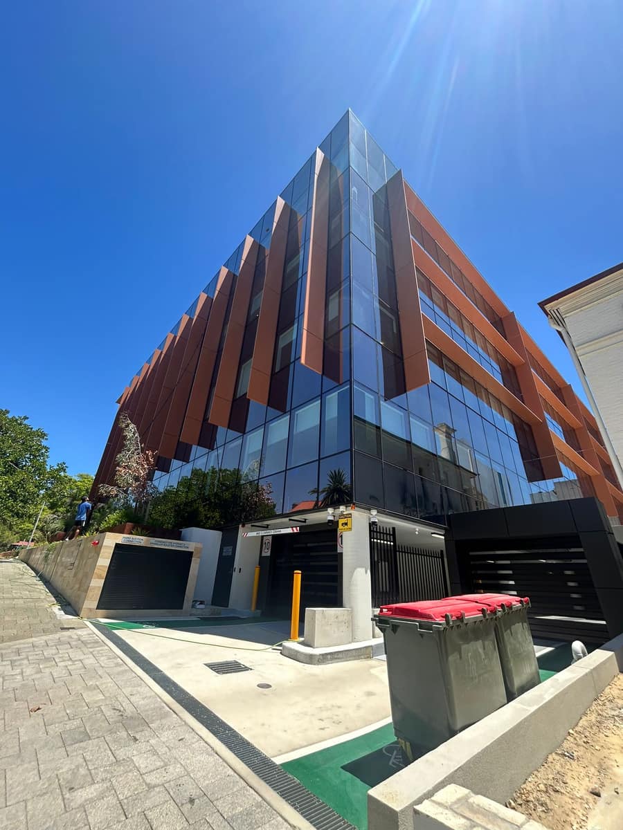 Dramatic upward angle of a glass and bronze fin commercial office building, Perth