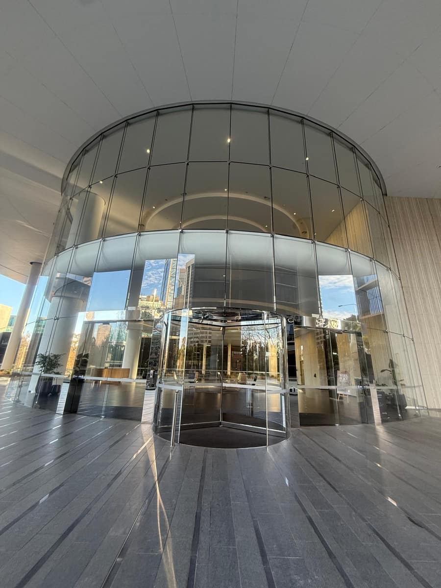 Wide angle of a clean glass revolving door entrance with city skyline reflected, Perth