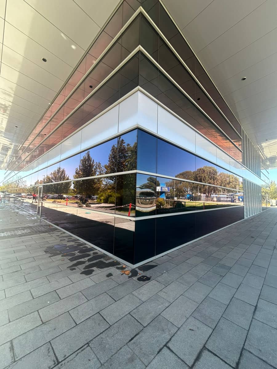 Reflective glass corner of a commercial building after a full exterior window clean, Purified Group Perth