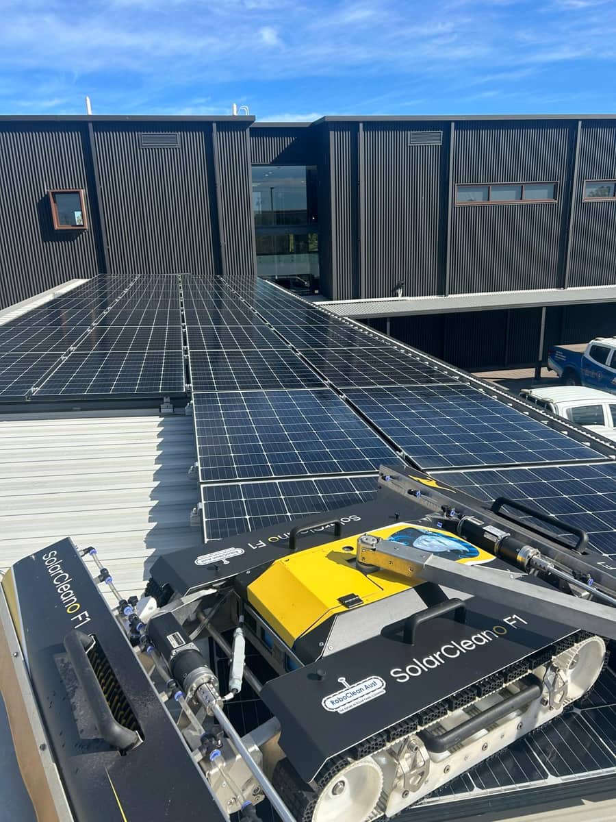 Robotic solar panel cleaner working across a commercial rooftop solar array, Purified Group Perth
