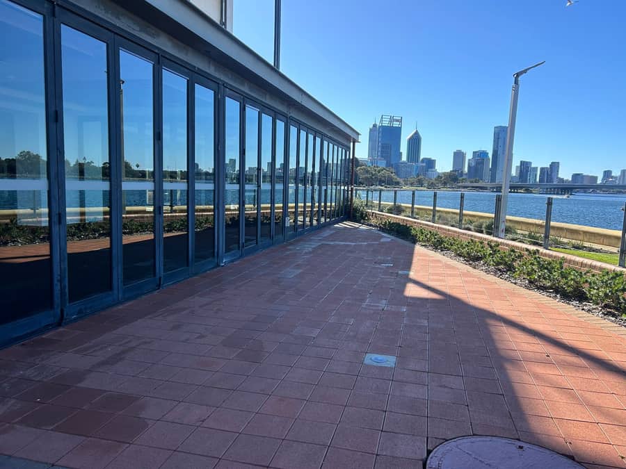 Riverside glass frontage along a Perth walkway, city skyline in the background, after cleaning