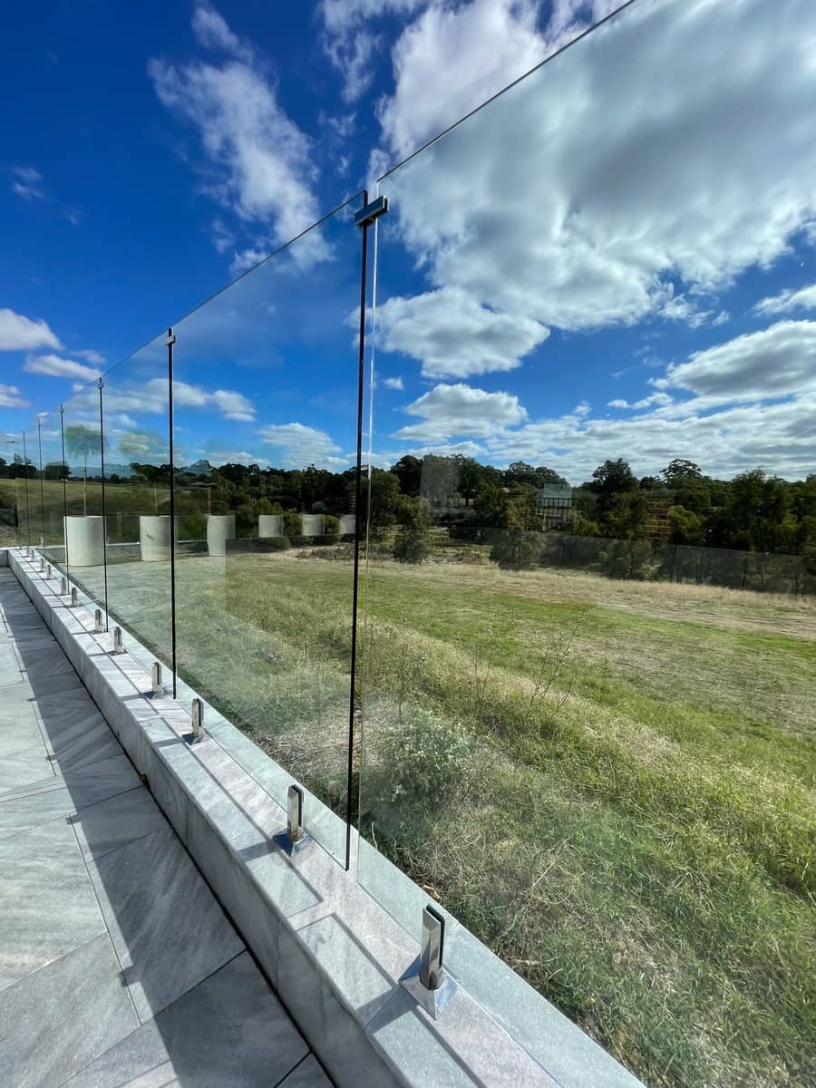 Glass pool fence bordering open land on a Perth property after cleaning