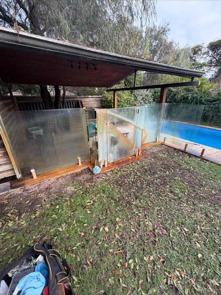 Before: streaked glass pool fence with rust residue, Perth