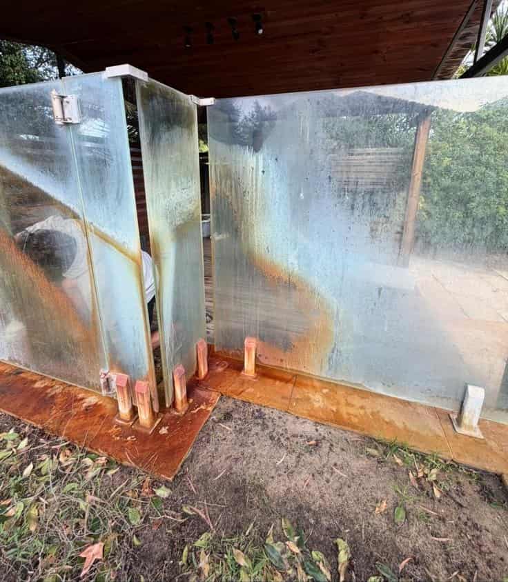 Before: streaked glass pool fence with rust residue, Perth