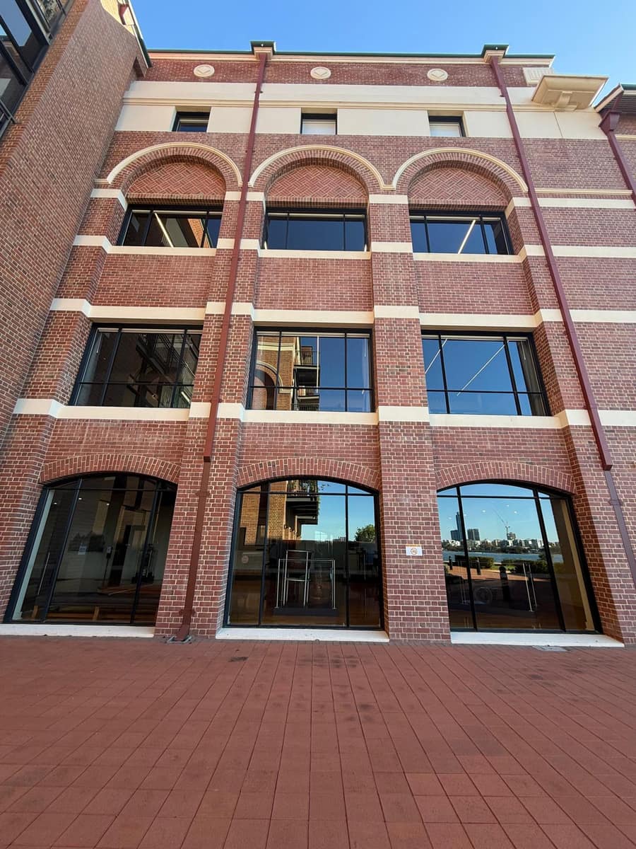 Heritage red brick building facade with clean glass windows, Perth
