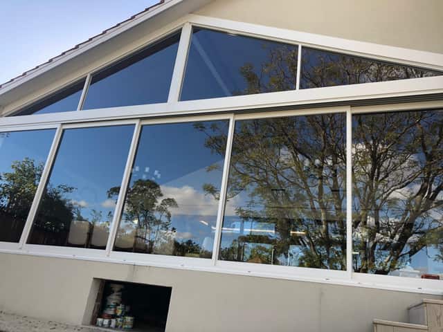 Clean gable windows reflecting the garden at a Perth home