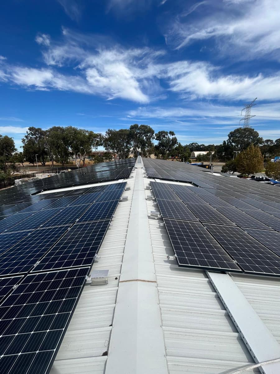 Clean commercial solar panels under a clear blue sky, Perth