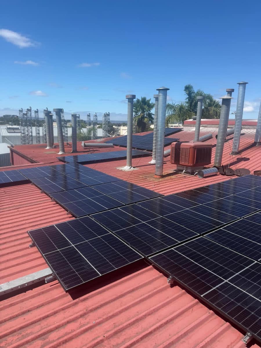 Clean solar panels on a red Colorbond commercial roof, Perth
