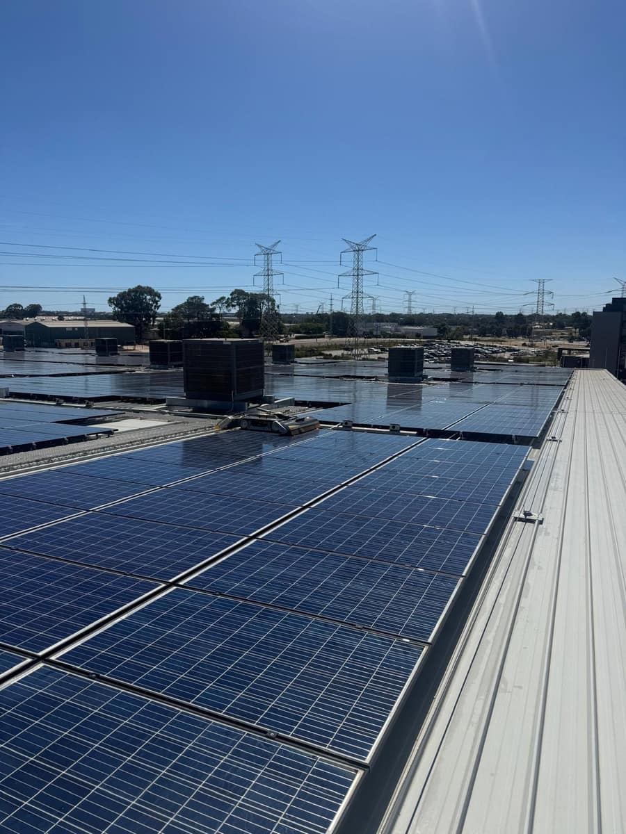 Wide view of a commercial solar panel array being cleaned, Perth