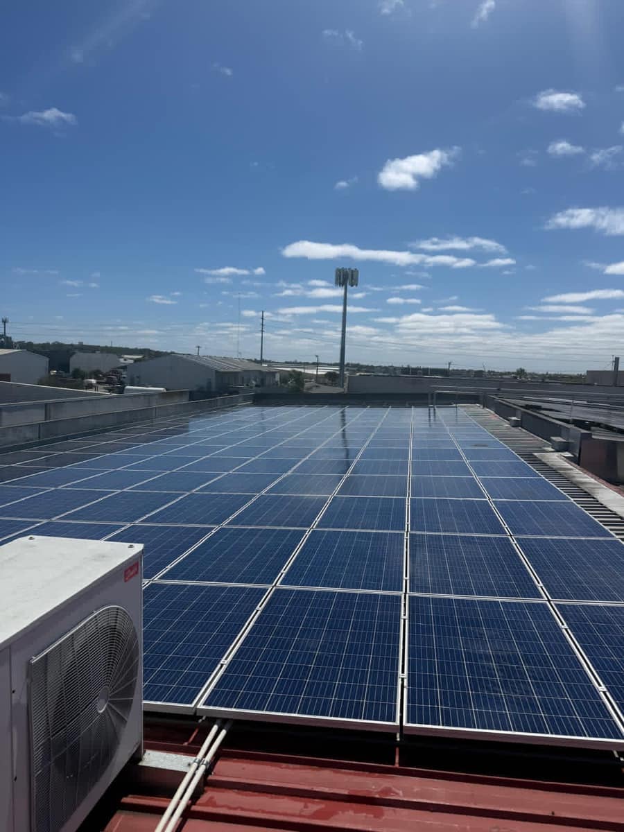 Wide rooftop view of a clean commercial solar panel array, Perth