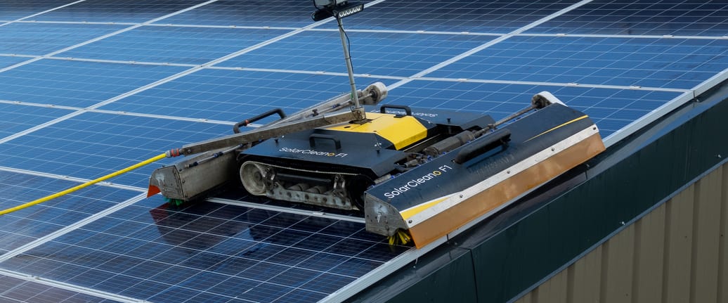 SolarCleano robotic cleaner on a curved commercial warehouse roof solar array, Perth