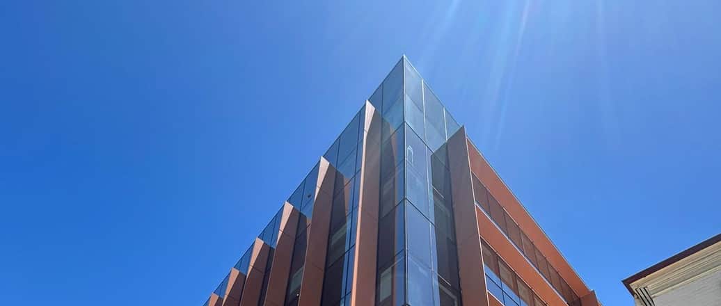 Glazed and bronze-finned commercial office tower rising against clear sky in Perth, WA