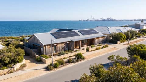 A beachside Perth home with solar panels under a hazy coastal sky, Kwinana Beach