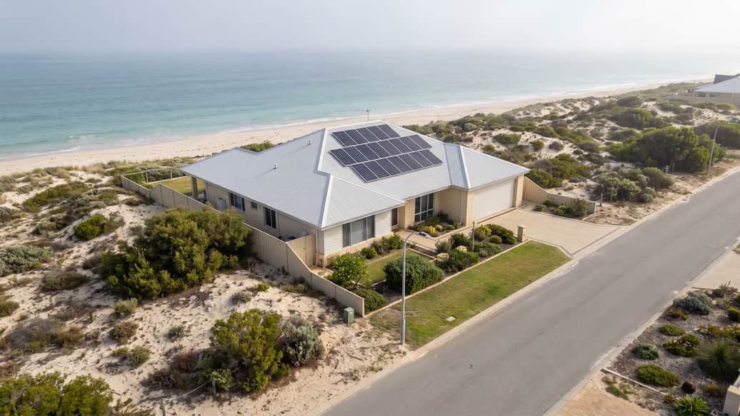 A beachside Perth home with solar panels under a hazy coastal sky, Lake Coogee