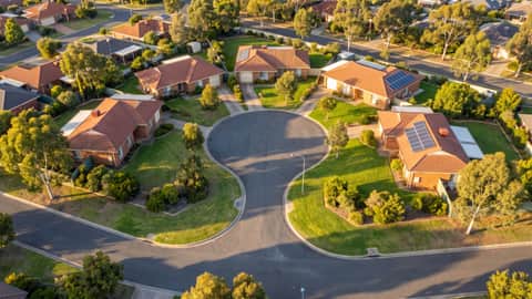 A leafy Perth suburban street with mature trees, a home with solar panels visible, Leeming