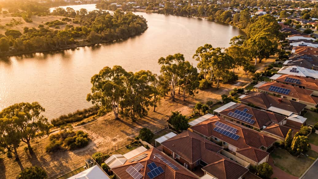 A Perth riverside suburb under jacaranda and gum trees, a home with solar panels visible, East Fremantle