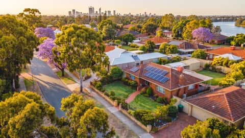 A Perth riverside suburb under jacaranda and gum trees, a home with solar panels visible, South Perth