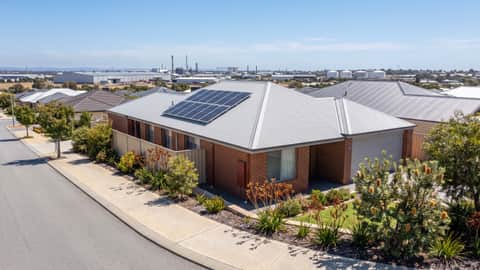 An established Perth home with solar panels, an industrial precinct visible on the horizon, Spearwood